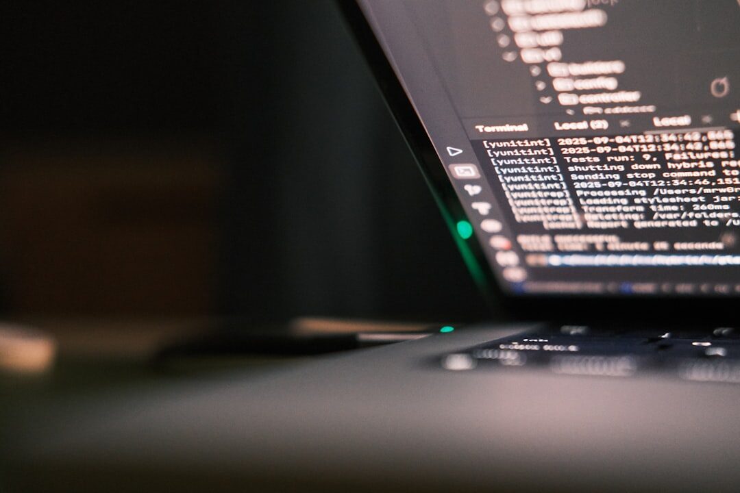 Developer coding on laptop with code on screen
